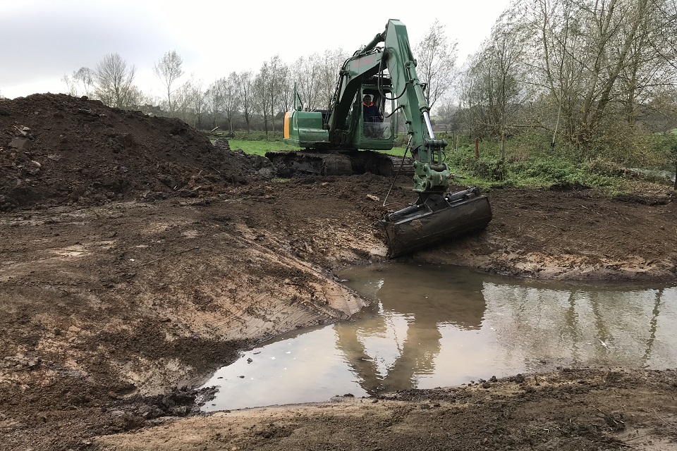 Construction work happening to create a backwater in a muddy field